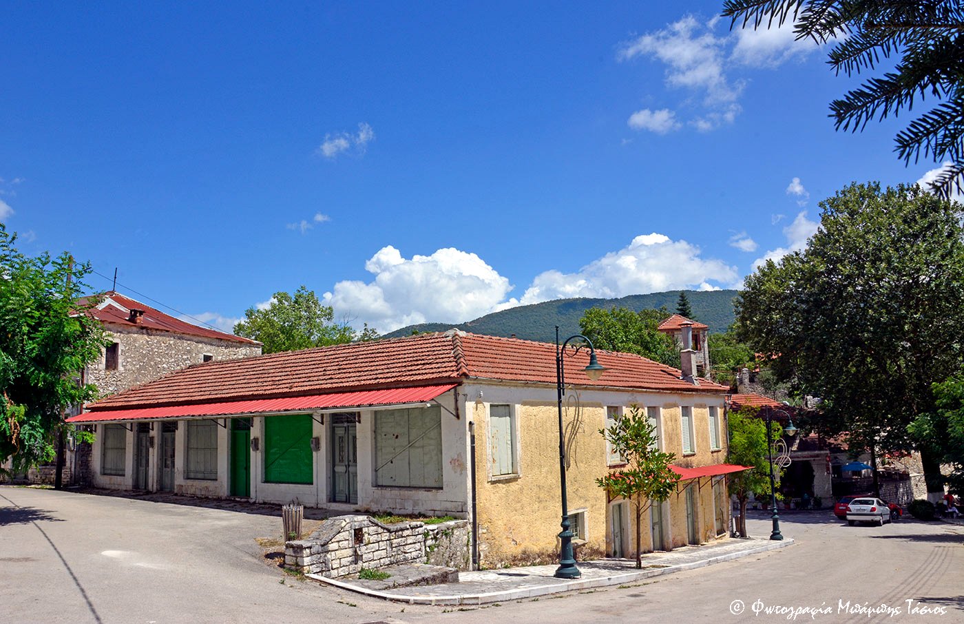 Η πλατεία της Πωγωνιανής με πέτρινα κτίρια και κόκκινες στέγες